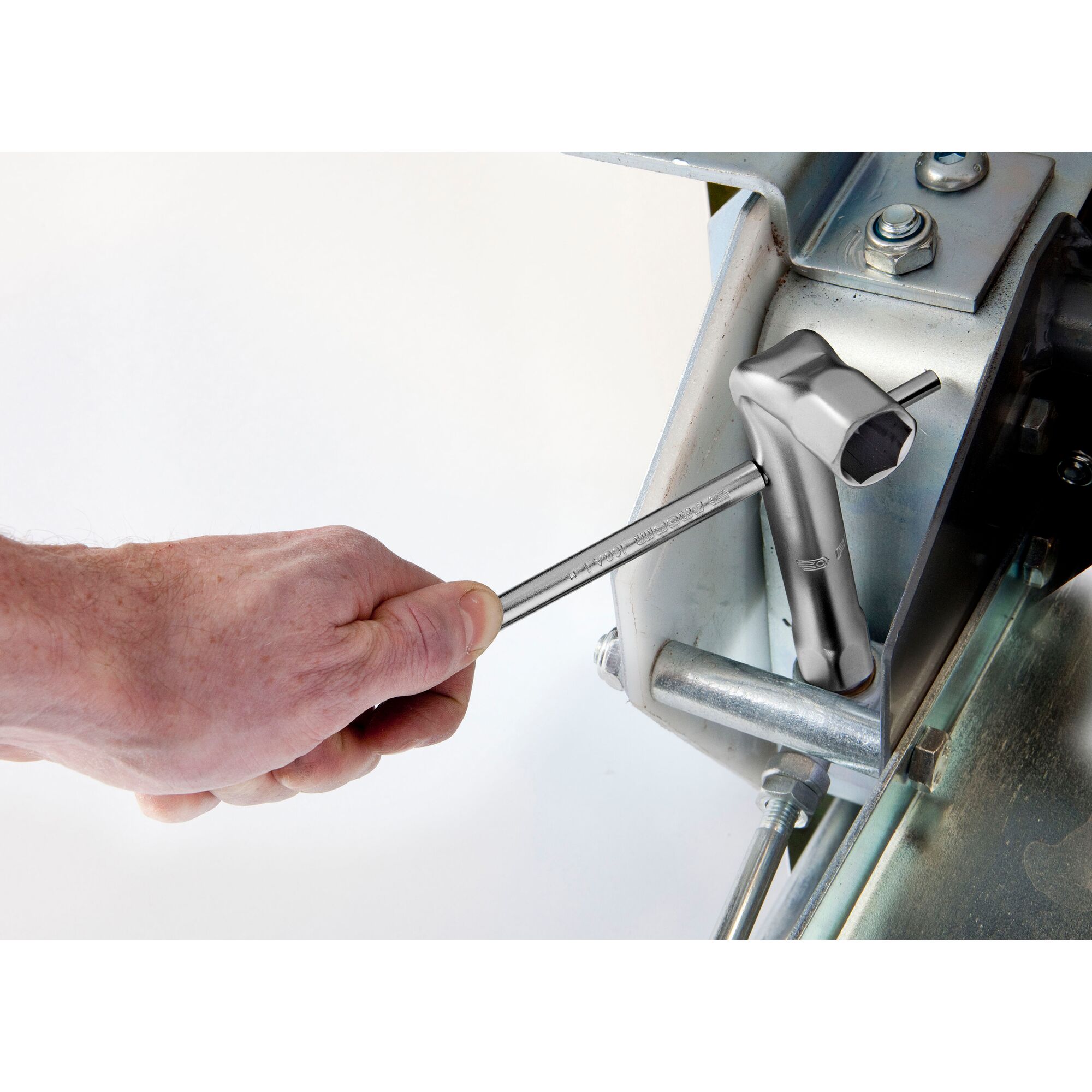 Facom socket wrench 92A_21 used to tighten a metal bolt on machinery, hand holding the tool.